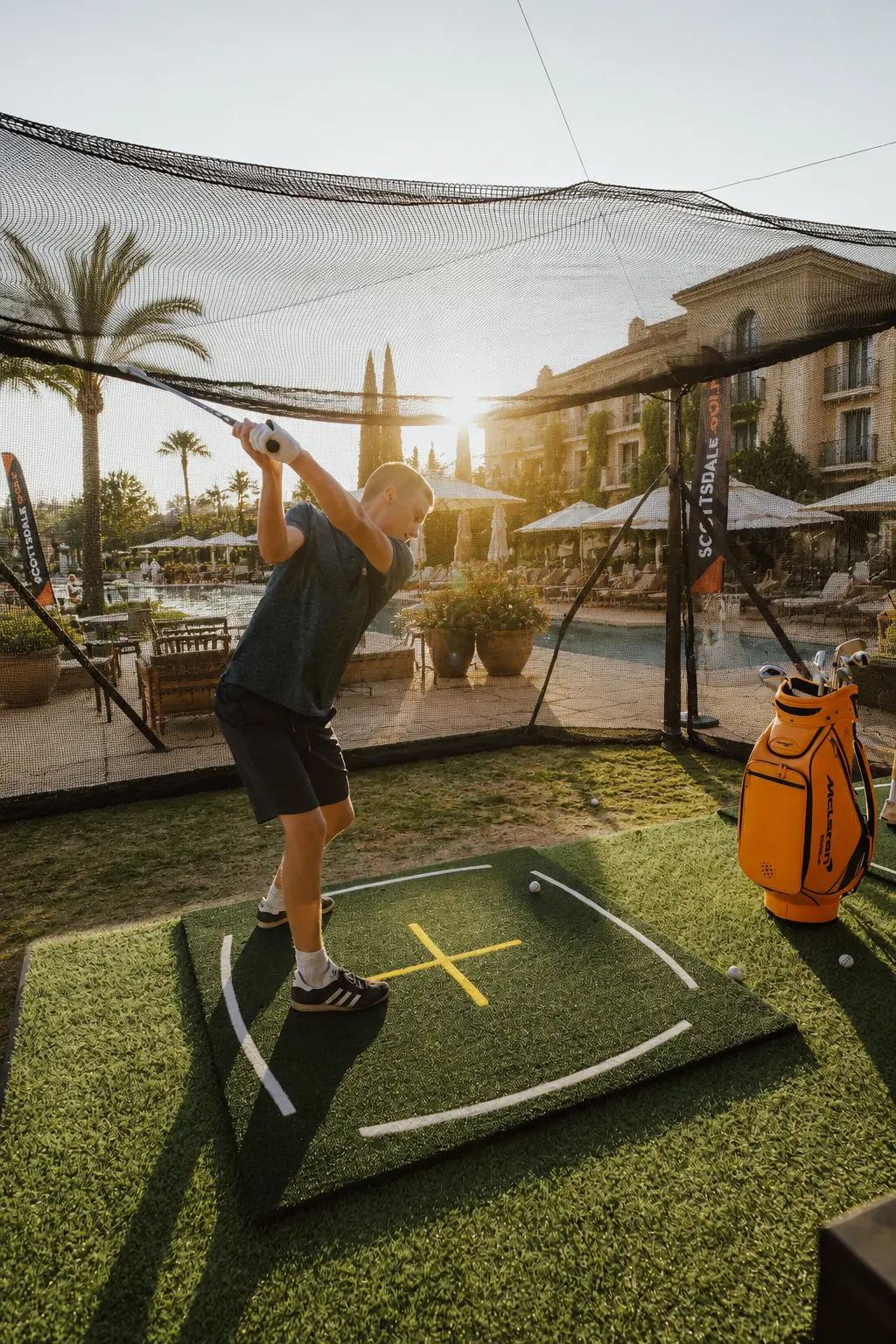 Outdoor tech-enabled driving range at a resort hotel at sunset